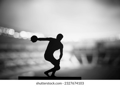 Silhouette of Athlete, Launching the Discus amidst Ethereal Evening Atmosphere. Track and Field Photo for Summer Games in Paris. - Powered by Shutterstock