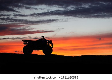 Silhouette ATV or Quad bike in the sunset. Holiday exploration concept with silhouette of quad bike