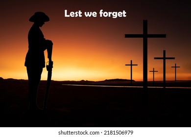 Silhouette Of An Australian Soldier With Arms Reversed Against A Golden Sunrise With Crosses In The Background. Anzac Day Concept.