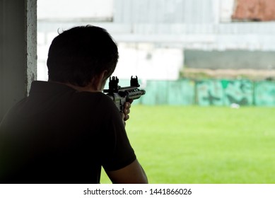 Silhouette Back Portrait Of Man Fires A Gun In Shooting Range Field