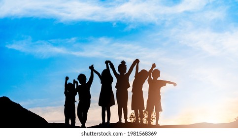 Silhouette-Rücken-Blick Flüchtlingskind-Gruppe spielen in Sonnenuntergang.Kind Junge und Mädchen Anbetung.Hobbyhure Hände segnen Gottesdienst, Hoffnung, Freiheit, Verzweiflung, Glaube, Lob, Welt-Flüchtlingstag.Adoption Kind.