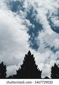 Silhouette of Bali temple roof at sunny day with cloudy sky backdrop, Indonesia.