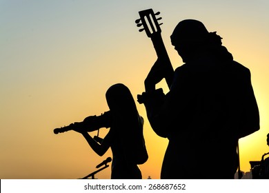 Silhouette Of Band Playing The Music At Sunrise