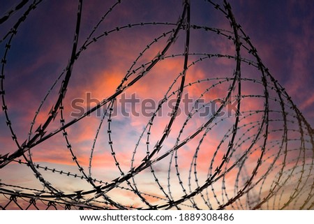 Similar – Fence with a barbed