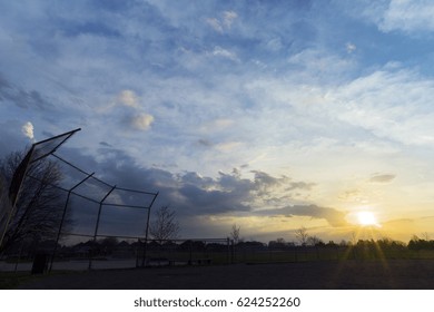 Silhouette of baseball diamond fence at dawn, beautiful sunrise sky with space for text - Powered by Shutterstock