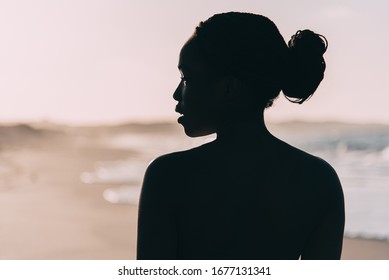 Silhouette of beautiful beach woman on the sunset beach