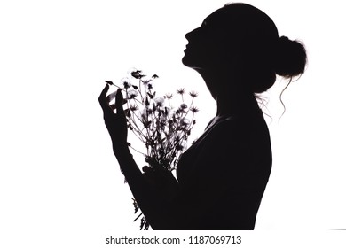 silhouette of a beautiful girl with a bouquet of dried flowers, face profile of a dreamy young woman looking upwards on a white isolated background, the concept of beauty and simplicity of happiness - Powered by Shutterstock