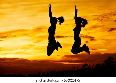 Silhouette beautiful woman jumping together above the dam at the sky sunset. - Shutterstock ID 656025175