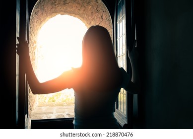 Silhouette Of Beautiful Woman Opening Window