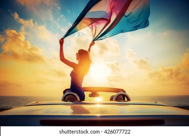 Silhouette of beautiful woman relaxing on the beach. Person having fun in cabriolet against blue sky background. Summer vacation and travel concept - Powered by Shutterstock