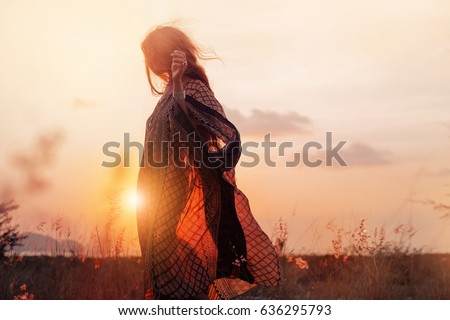  silhouette of beautiful young woman at sunset