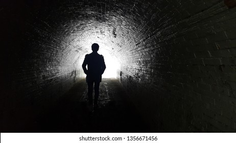 The Silhouette Behind The Man Went Straight Into The Tunnel. The Destination Has Light At The End.Black And White Image Means Go To The Goal.