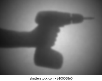 Silhouette behind a transparent paper - Blurred - Cordless drill - Powered by Shutterstock