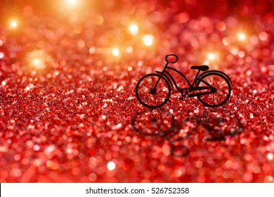 Silhouette of a bicycle in christmas night with red glitter bokeh and snow abstract background.
