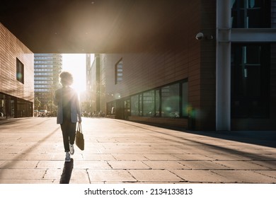Silhouette of Black business woman walking in a financial district in the city using phone going to office work. Concept of inspiration, enthusiasm, start-up, feminism - Shutterstock ID 2134133813