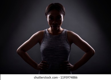 Silhouette Of Black Female In An Angry Pose Or Portrait Of An Athlete Concentrating For An Extreme Sport Competition. The Face Is In Shadow To Portray Anger Or Rage.