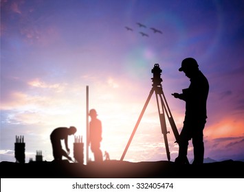 silhouette black man survey and civil engineer stand on ground working in a land building site over Blurred construction worker on construction site. examination, inspection, survey