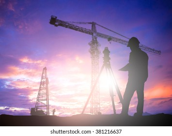 Silhouette Black Man Survey And Civil Engineer Stand On Ground Working In A Land Building Site Over Blurred Construction Worker On Construction Site. Examination, Inspection, Survey