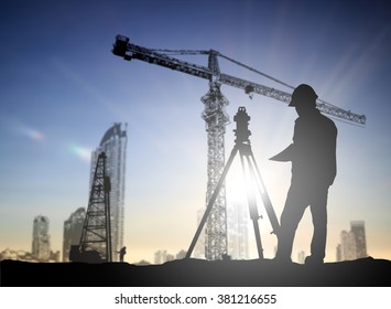 Silhouette Black Man Survey And Civil Engineer Stand On Ground Working In A Land Building Site Over Blurred Construction Worker On Construction Site. Examination, Inspection, Survey