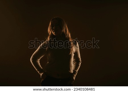 Silhouette of a blonde girl posing at the studio