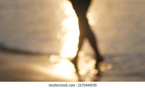 Silhouette Blurred Slow Motion Of A Woman Walking On The Beach Before Sunset