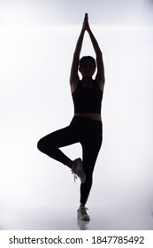 Silhouette Body Of Young Fitness Woman Play Sweat Yoga And Stretch Muscle For Slim Sexy Shape. High Contrast White Background Copy Space