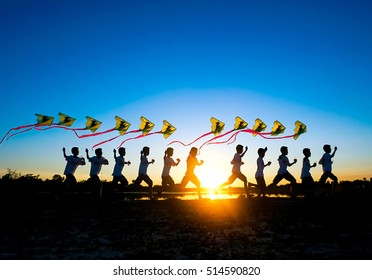 Silhouette Of The Boy Flying A Kite In Sunset Background. , Multiple Action , The Joy Of Children Playing Kites. Happy Childhood