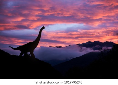 Silhouette of a brachiosaurus at sunrise in the jurassic era.