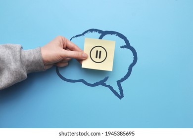 The silhouette of the brain and the pause icon on the sticker. A symbol of the need to rest the brain