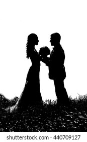 silhouette of bride and groom in the grass on a white background