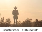 Silhouette of bushes and a Anzac monument in a soft afternoon light. The monument is an Australian World War One Digger standing guard. Remembrance Day - Anzac Day. Alan Somerville