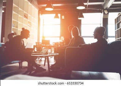 Silhouette Of Business Group Brainstorming New Plan. Team Meeting On The Couch. Big Open Space Office. Five People. Intentional Sun Glare