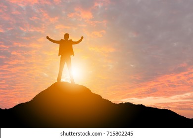 Silhouette of Business man Celebration Success Happiness on a mountain top Sunset Evening Sky Background, Sport and active life Concept, with clipping path.