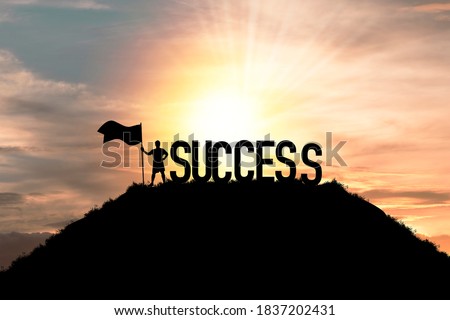 Silhouette business man standing and holding flag with success wording on the top of mountain, business success and achievement objective target concept.