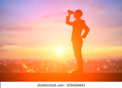 silhouette of business man take binocular telescope with sunset - Powered by Shutterstock