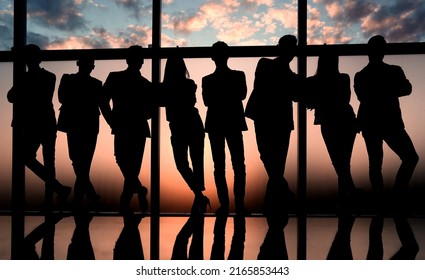 silhouette of a business team standing next to the office window - Shutterstock ID 2165853443