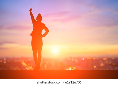 silhouette of business woman feel excited with sunset