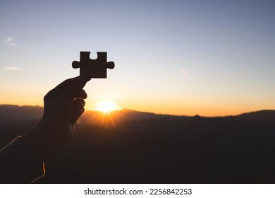 Silhouette of business woman hand holding  jigsaw puzzle piece against sunrise, Business solutions, target, success, goals and strategy concepts - Shutterstock ID 2256842253