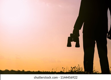 Silhouette of Businessman with binoculars to look for opportunities for success.