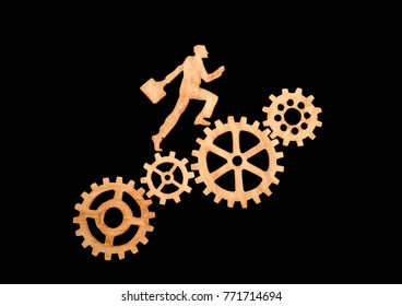 silhouette of a businessman with a briefcase going to success through gear set. Career growth, promotion, and teamwork. Of natural wood black background. - Powered by Shutterstock