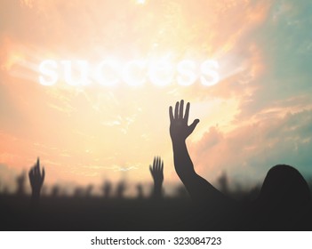Silhouette businessman raising hands over text for SUCCESS on beautiful autumn sunset background - Shutterstock ID 323084723