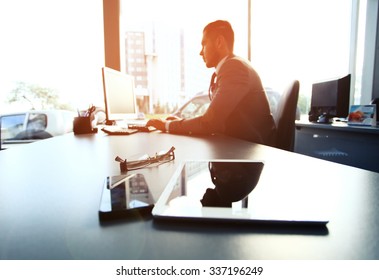 Silhouette of businessman using laptop in office - Shutterstock ID 337196249