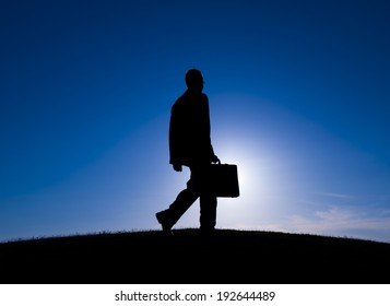 Silhouette of a Businessman walking outdoors.