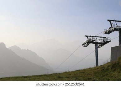 silhouette of cable car masts with a monochrome background of mountains in the fog - Powered by Shutterstock