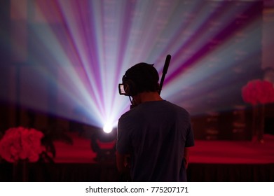 Silhouette Of A Cameraman Handling A Live Feed Camera With Ray Of Light In The Background.