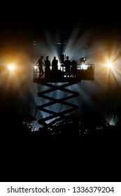 Silhouette Of Cameraman Operator Shooting A Live Rock Concert, Film Crew On The Lift