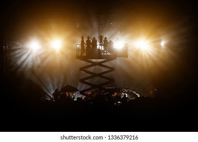 Silhouette Of Cameraman Operator Shooting A Live Rock Concert, Film Crew On The Lift