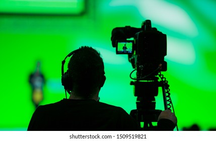 Silhouette Of A Cameraman And Video Camera At Live Broadcast News Event 