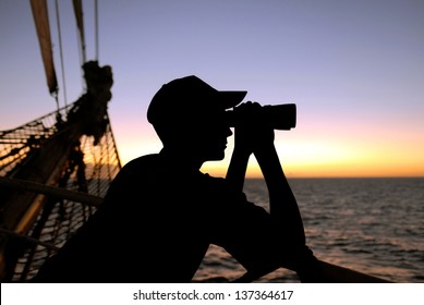 silhouette captain looking through binoculars