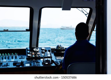 Silhouette Of Captain Steering Boat